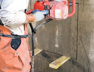Holzkeile werden zur Stabilisierung eines Betonrechtecks verwendet, das aus einem Fundament herausgeschnitten wird